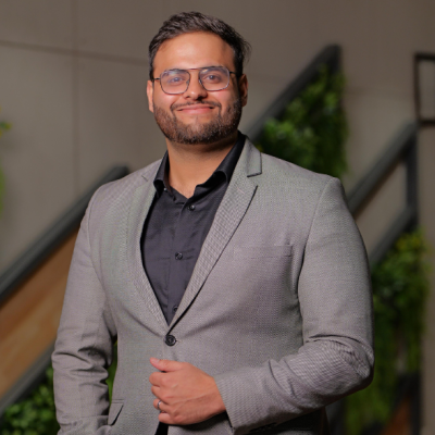 A portrait of Soham Chimote, wearing a business casual outfit, with a friendly expression.
